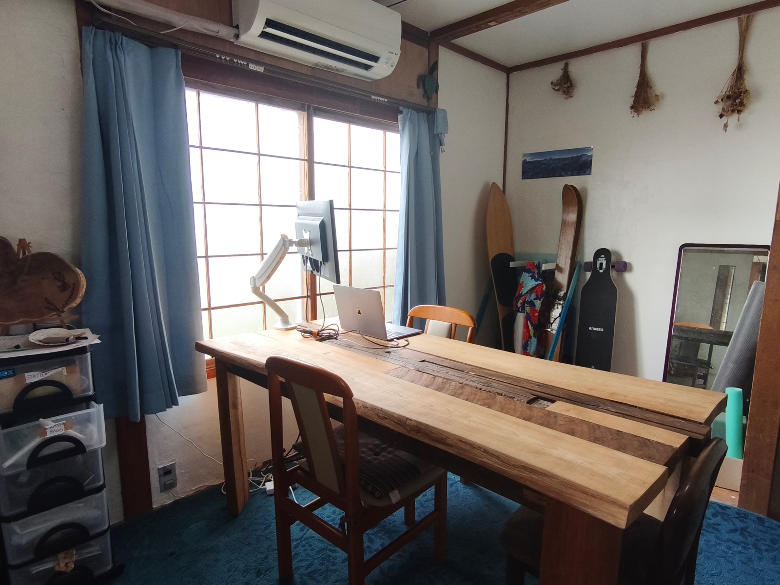 MOTO Colivingの共用デスク。木のテーブルとモニター、ノートPC
